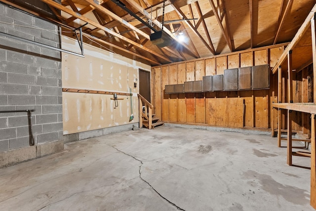 garage featuring a garage door opener and concrete block wall
