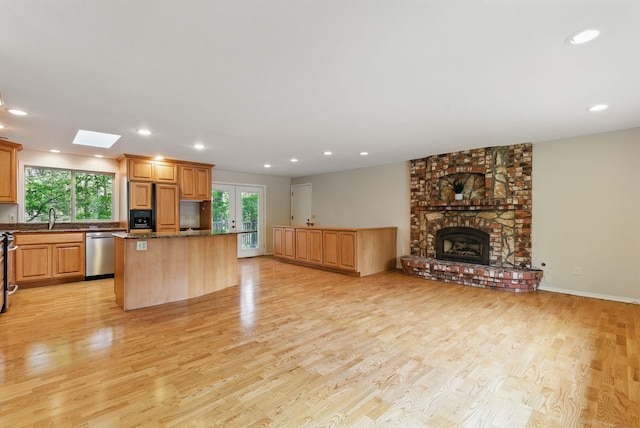 kitchen with a center island, appliances with stainless steel finishes, plenty of natural light, light wood-type flooring, and recessed lighting