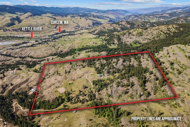 aerial view of property and surrounding area with a mountain backdrop and property boundaries highlighted