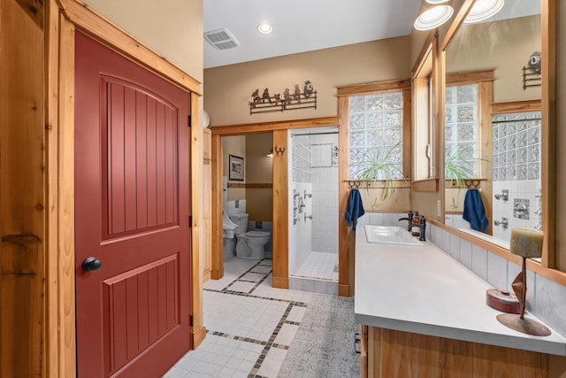 bathroom featuring toilet, a shower stall, vanity, tile patterned floors, and inlaid floor details