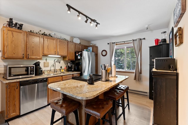 328 Bayview Dr Unit 12, Coolin, ID 83821 - kitchen featuring stainless steel appliances, a sink, a breakfast bar area, light wood finished floors, and a center island