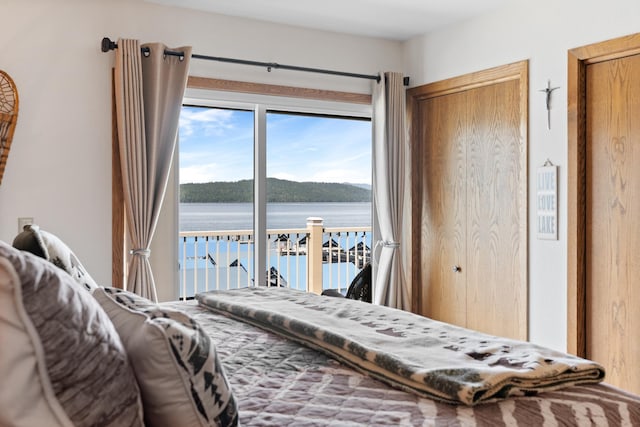 328 Bayview Dr Unit 12, Coolin, ID 83821 - bedroom with access to exterior, a water view, and multiple closets