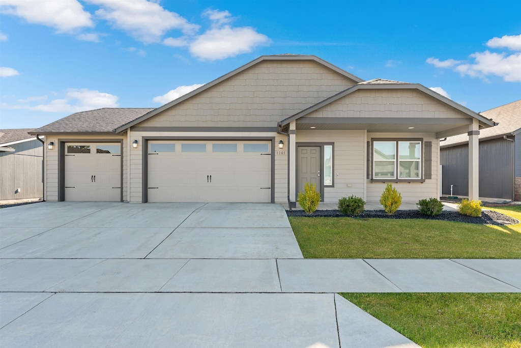 1101 S Pillar Rock Dr, Spokane, WA 99224 - view of front of home with a garage, a front yard, and concrete driveway