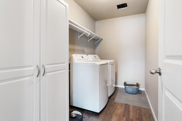 washroom featuring washer and dryer, dark wood-style flooring, and baseboards