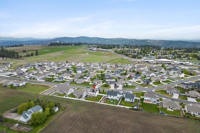 aerial view of property and surrounding area with a mountain backdrop and nearby suburban area