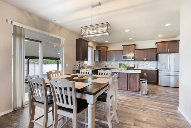 dining space with light wood finished floors, recessed lighting, and baseboards
