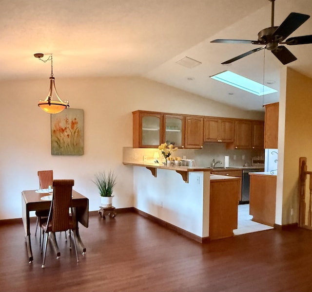 1610 S Newer Ln Unit 0, Spokane Valley, WA 99037 - kitchen with a peninsula, wood finished floors, glass insert cabinets, a skylight, and vaulted ceiling