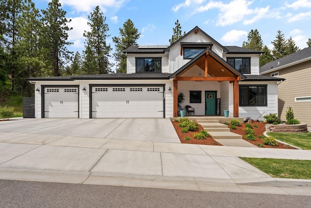 2007 E 33rd Ave, Spokane, WA 99203 - view of front of property featuring solar panels, concrete driveway, an attached garage, and covered porch
