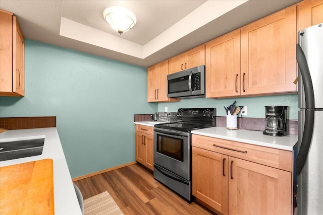 172 S Coeur Dalene St Unit G304, Spokane, WA 99204 - kitchen featuring appliances with stainless steel finishes, dark wood-style flooring, light countertops, a raised ceiling, and light brown cabinets