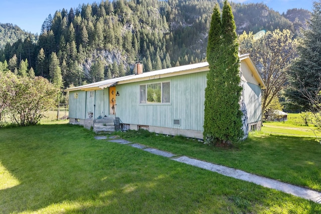 4345 Wilcox Rd, Northport, WA 99157 - view of front of home with a front lawn, a chimney, and a view of trees
