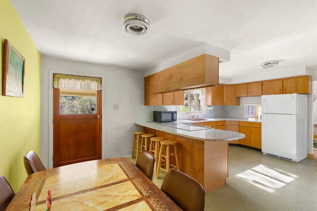 4345 Wilcox Rd, Northport, WA 99157 - kitchen featuring white appliances, a peninsula, light countertops, and healthy amount of natural light