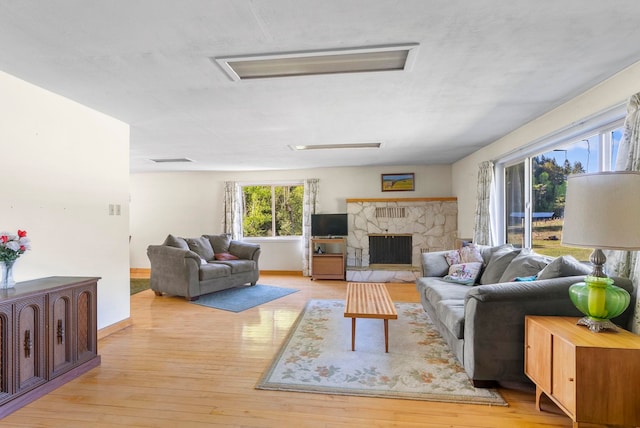 4345 Wilcox Rd, Northport, WA 99157 - living room featuring wood-type flooring, a stone fireplace, and baseboards