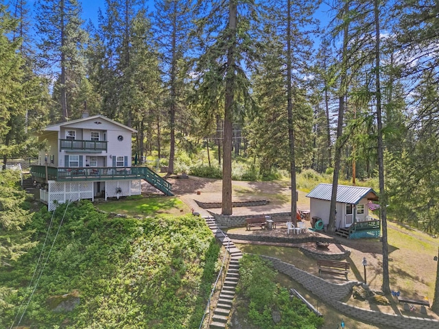 231 Mountain View Dr, Newport, WA 99156 - view of yard featuring stairs, a deck, an outdoor structure, and view of wooded area