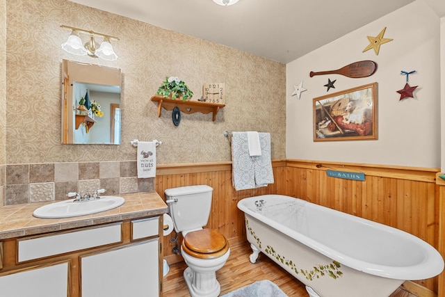 231 Mountain View Dr, Newport, WA 99156 - bathroom with wainscoting, wood finished floors, toilet, a freestanding tub, and vanity