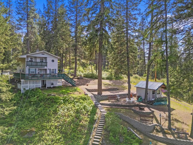 231 Mountain View Dr, Newport, WA 99156 - view of yard featuring a wooden deck, stairs, a fire pit, and an outbuilding