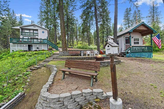 231 Mountain View Dr, Newport, WA 99156 - view of yard featuring stairs, a deck, an outbuilding, and an outdoor fire pit