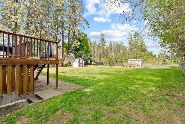 view of yard with an outdoor structure, a shed, stairs, and a deck