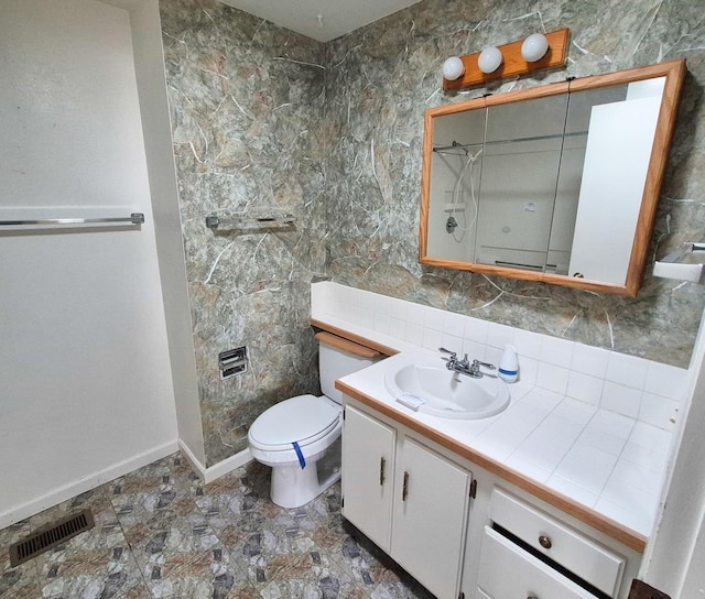 306 S Bernard St, Chewelah, WA 99109 - bathroom featuring vanity, toilet, decorative backsplash, baseboards, and a shower