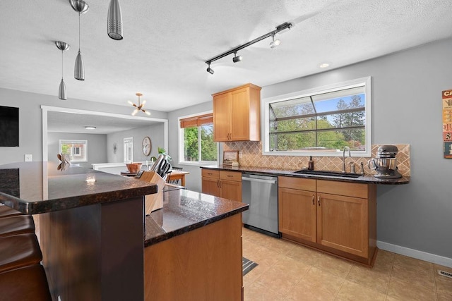 8214 N Jefferson Dr, Spokane, WA 99208 - kitchen featuring dishwasher, a sink, backsplash, a breakfast bar, and dark stone counters