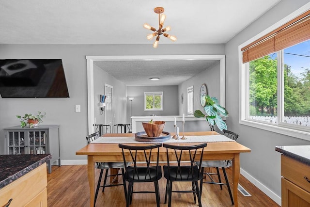 8214 N Jefferson Dr, Spokane, WA 99208 - dining room featuring wood finished floors, a chandelier, and baseboards