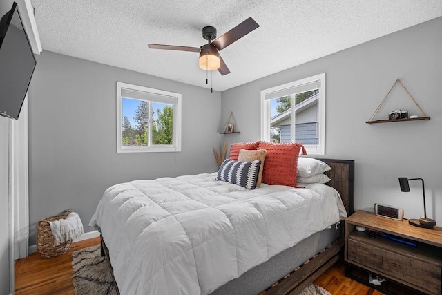 8214 N Jefferson Dr, Spokane, WA 99208 - bedroom featuring multiple windows, wood finished floors, a textured ceiling, and ceiling fan