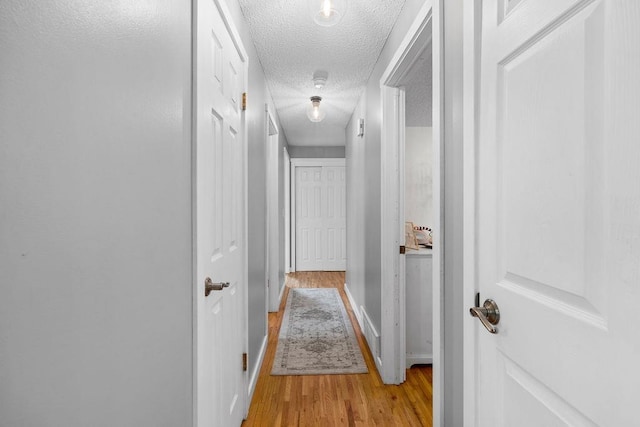 8214 N Jefferson Dr, Spokane, WA 99208 - hallway featuring a textured ceiling, light wood-style floors, and baseboards