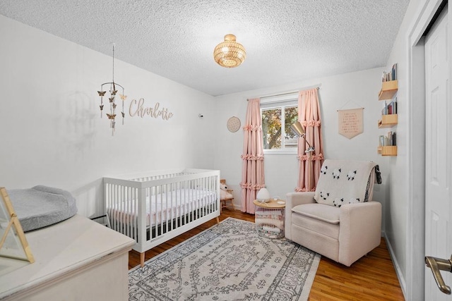 8214 N Jefferson Dr, Spokane, WA 99208 - bedroom with wood finished floors, a textured ceiling, and a nursery area