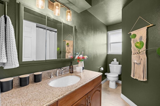 8214 N Jefferson Dr, Spokane, WA 99208 - bathroom with vanity, toilet, baseboards, a textured ceiling, and a textured wall