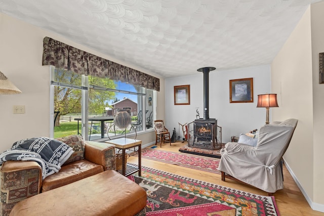 2443 Flowery Trail Rd, Usk, WA 99180 - living room featuring wood finished floors, a wood stove, and baseboards