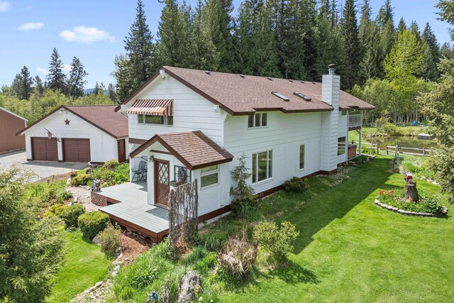 2443 Flowery Trail Rd, Usk, WA 99180 - rear view of house featuring an outbuilding, a yard, a chimney, a garage, and a wooden deck
