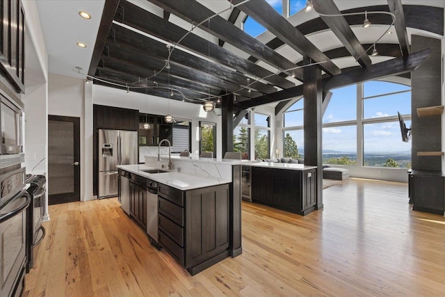2503 S Thierman Ln, Spokane, WA 99223 - kitchen with a sink, a center island with sink, light countertops, stainless steel appliances, and light wood-type flooring