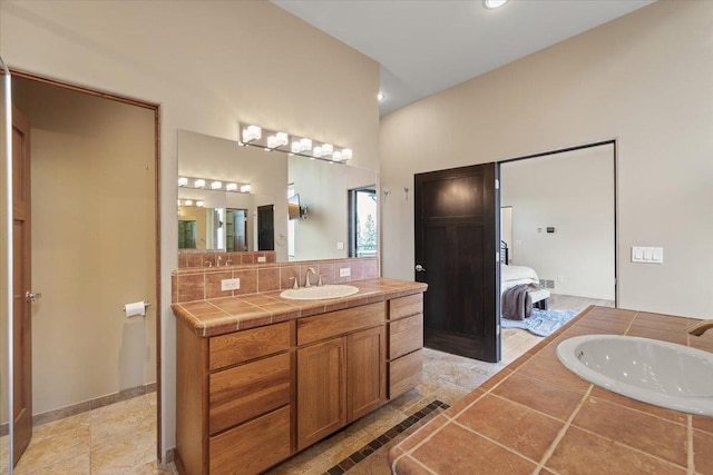 2503 S Thierman Ln, Spokane, WA 99223 - ensuite bathroom featuring decorative backsplash, vanity, tiled tub, and recessed lighting