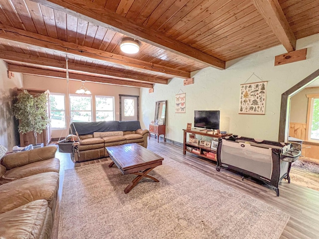 living room featuring wood finished floors, wood ceiling, healthy amount of natural light, and beam ceiling