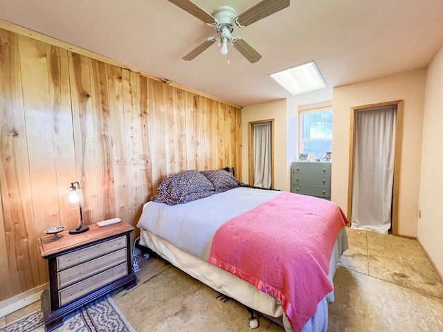 bedroom with wooden walls and a ceiling fan