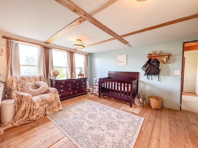bedroom featuring hardwood / wood-style flooring and beam ceiling