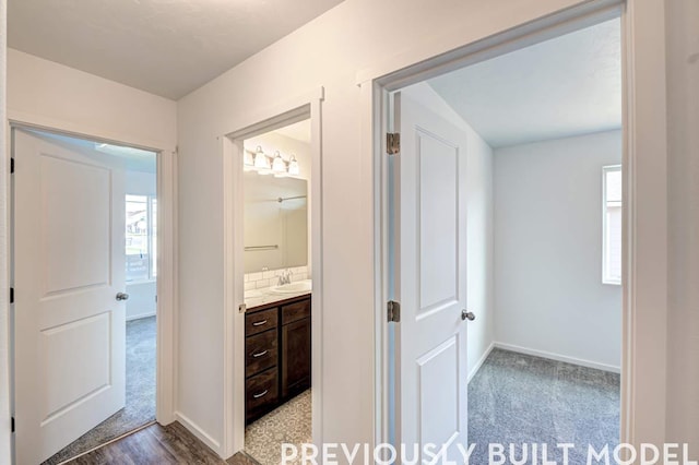 18806 E Riverside Ct, Spokane Valley, WA 99016 - hallway with baseboards, a sink, carpet flooring, and wood finished floors