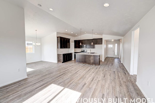18806 E Riverside Ct, Spokane Valley, WA 99016 - kitchen featuring stainless steel appliances, open floor plan, light wood-style flooring, lofted ceiling, and an island with sink