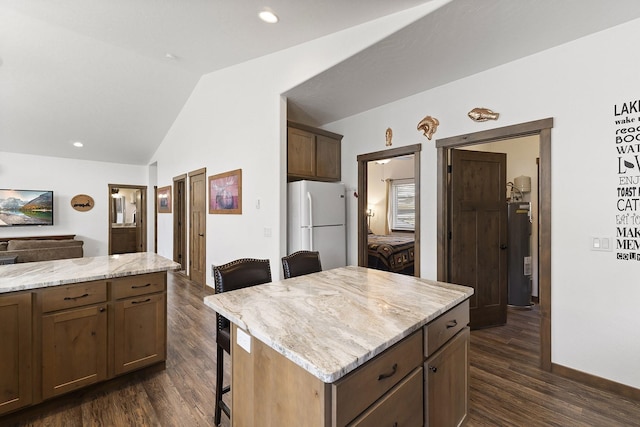 29955 N Isle View Rd, Spirit Lake, ID 83869 - kitchen with freestanding refrigerator, water heater, lofted ceiling, dark wood-style floors, and a kitchen bar