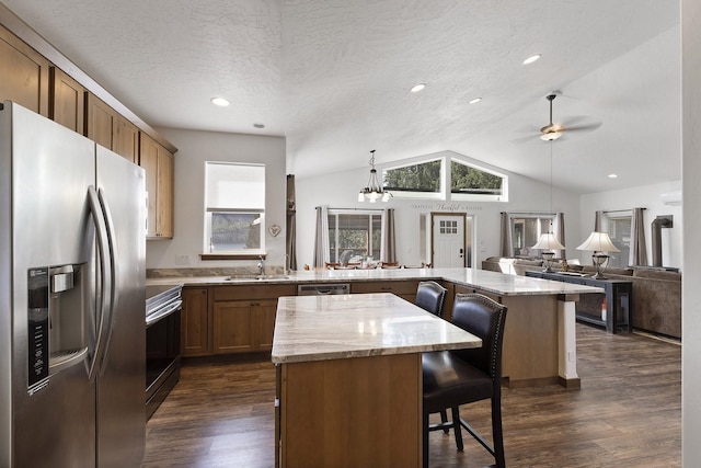 29955 N Isle View Rd, Spirit Lake, ID 83869 - kitchen featuring appliances with stainless steel finishes, a peninsula, healthy amount of natural light, a kitchen breakfast bar, and vaulted ceiling