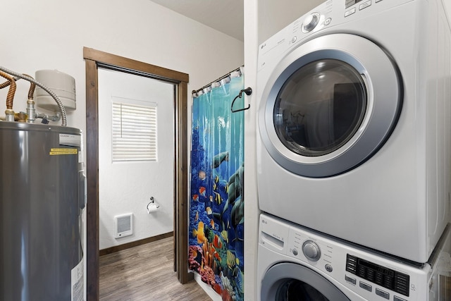 29955 N Isle View Rd, Spirit Lake, ID 83869 - laundry area featuring estacked washer and dryer, electric water heater, wood finished floors, baseboards, and heating unit