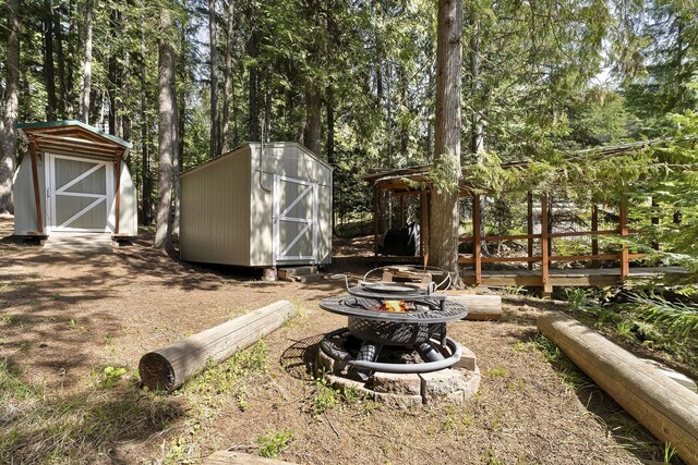 29955 N Isle View Rd, Spirit Lake, ID 83869 - view of yard with a storage unit, a fire pit, and an outdoor structure