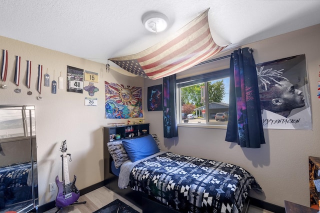 1503 E 3rd Ave, Post Falls, ID 83854 - bedroom with wood finished floors, baseboards, and a textured ceiling