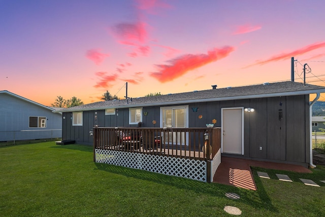 1503 E 3rd Ave, Post Falls, ID 83854 - rear view of property featuring a lawn, a wooden deck, and board and batten siding