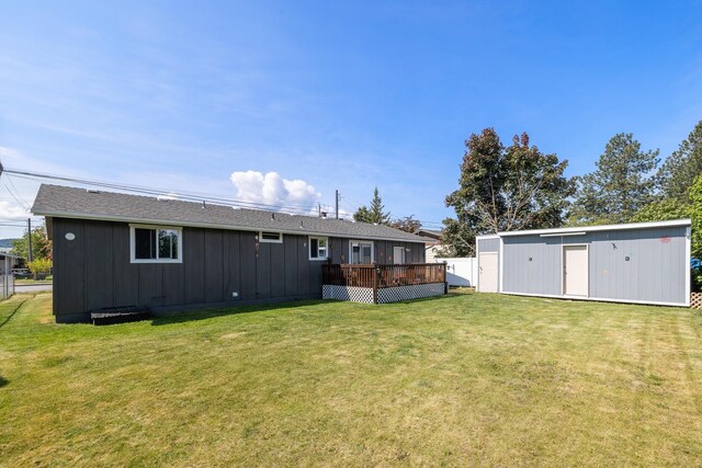 1503 E 3rd Ave, Post Falls, ID 83854 - rear view of property featuring a deck, a lawn, and board and batten siding
