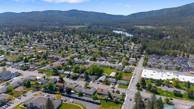 1503 E 3rd Ave, Post Falls, ID 83854 - aerial overview of property's location featuring a heavily wooded area, mountains, and nearby suburban area