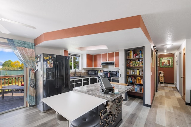 1503 E 3rd Ave, Post Falls, ID 83854 - kitchen featuring black fridge, a sink, stainless steel range with electric stovetop, under cabinet range hood, and light wood-style floors