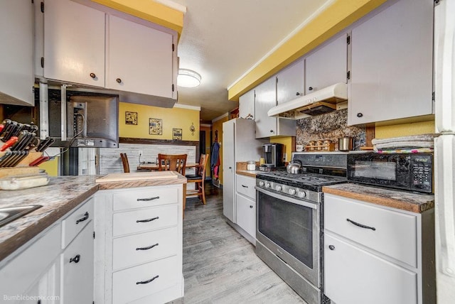 203 N Mcdonald Rd, Spokane, WA 99216 - kitchen with gas stove, under cabinet range hood, black microwave, tasteful backsplash, and light wood finished floors