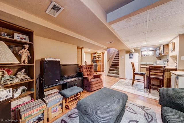 203 N Mcdonald Rd, Spokane, WA 99216 - living room featuring stairs, light wood-style floors, and a paneled ceiling