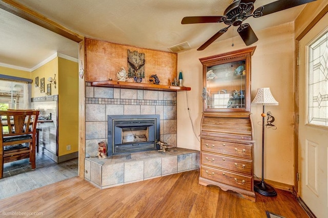 203 N Mcdonald Rd, Spokane, WA 99216 - living room with wood finished floors, a ceiling fan, a tile fireplace, baseboards, and ornamental molding