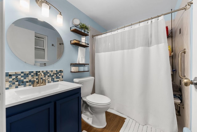 11010 E 28th Ave, Spokane, WA 99206 - full bath featuring toilet, vanity, backsplash, wood finished floors, and a shower with shower curtain